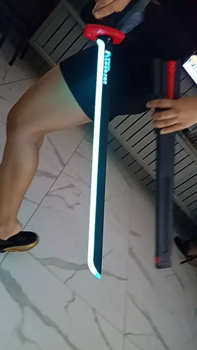 Katana com lâmina LED branca acesa na mão de uma cliente