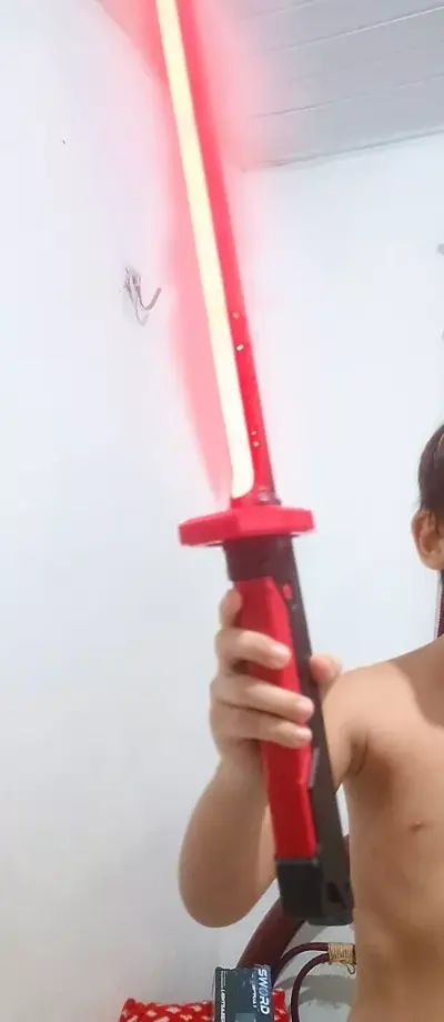 Criança segurando a katana com a lâmina LED vermelha acesa